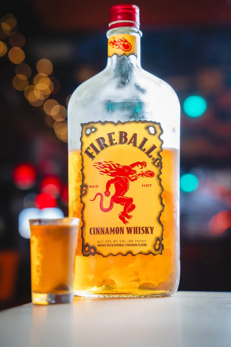 A cinnamon whisky shot next to the bottle