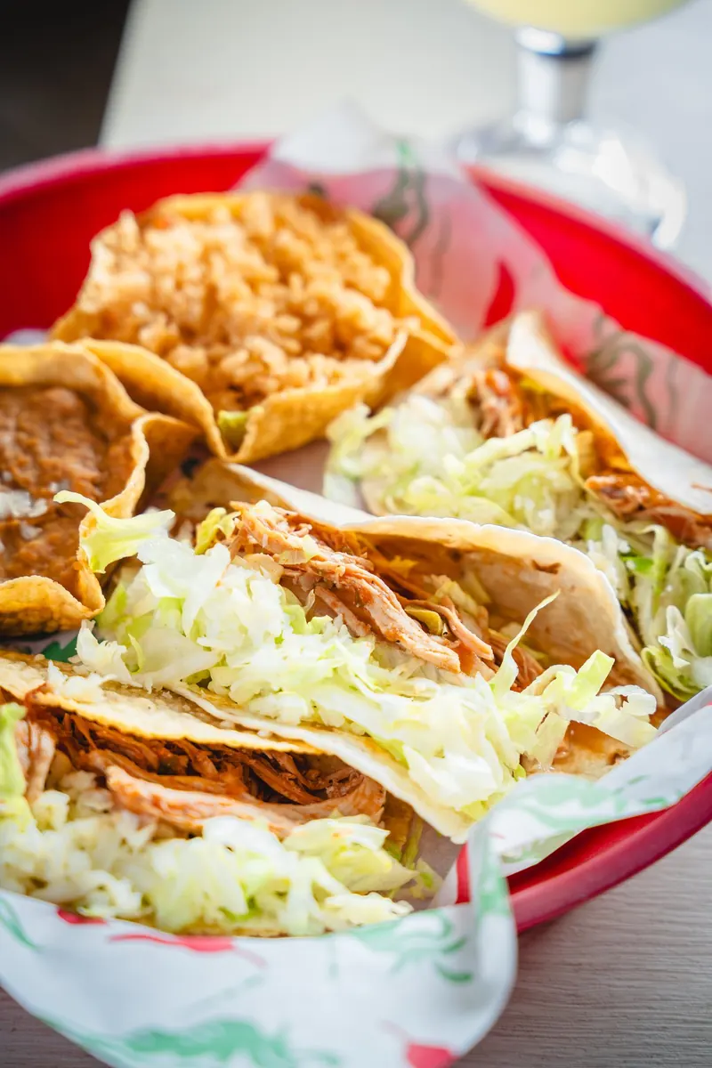 Crispy and soft tacos with lettuce in a red basket