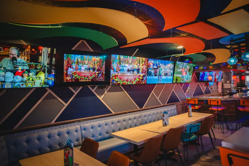 The bar with TVs under the hexagon ceiling
