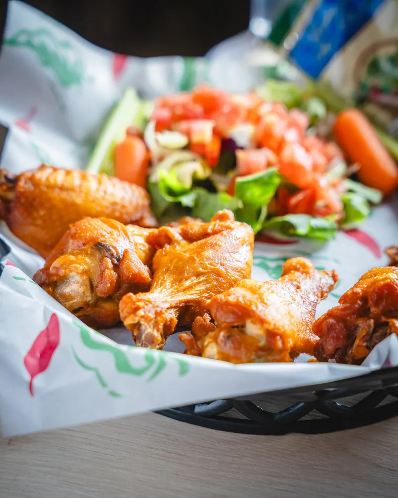 Chicken wings in a basket with carrots and pico